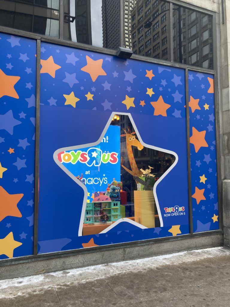 A photo of a window advertising Toys R Us at a Macy's store in Chicago.