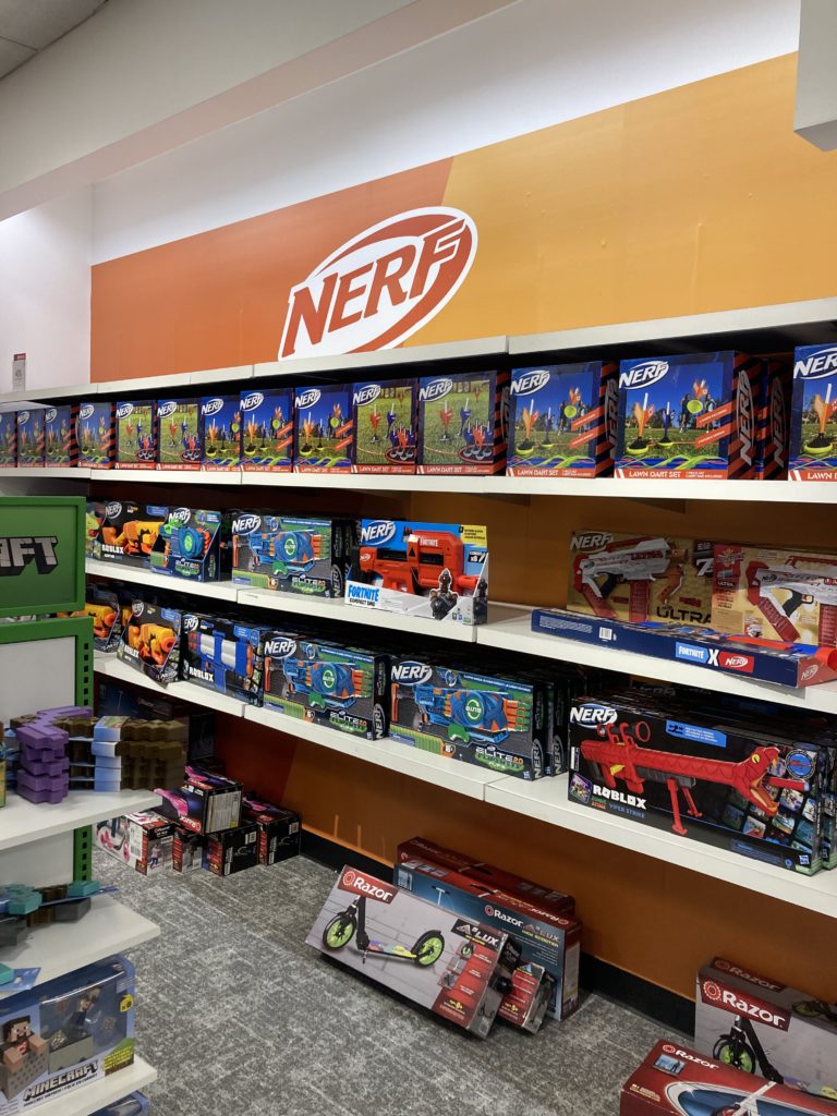 A set of wall shelves with multiple NERF guns. The NERF logo is painted above.